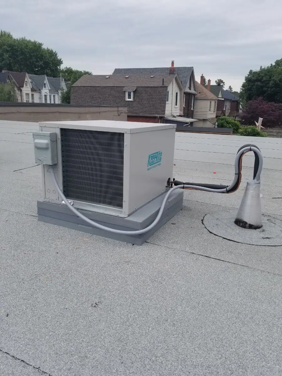 A rooftop air conditioning unit, expertly installed by an HVAC contractor in Brampton, graces the flat roof with houses visible in the background.