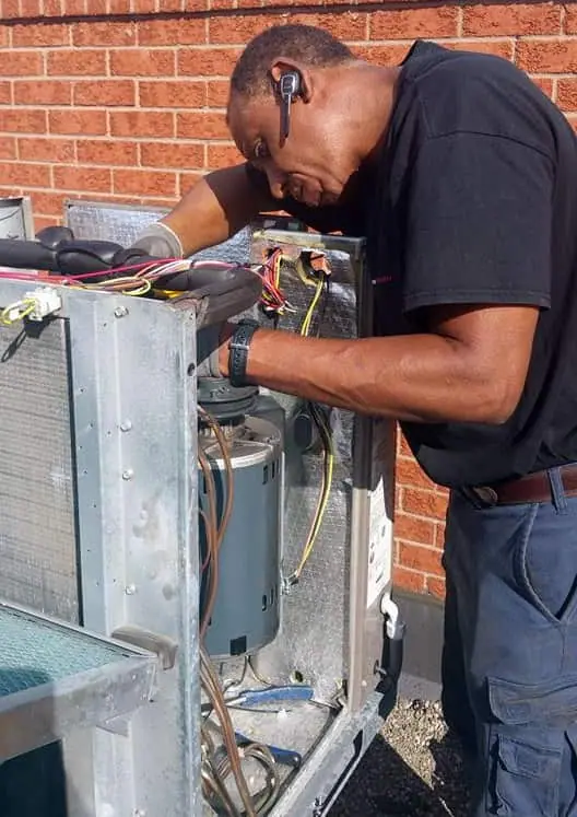 a man fixing a machine and providing hvac service